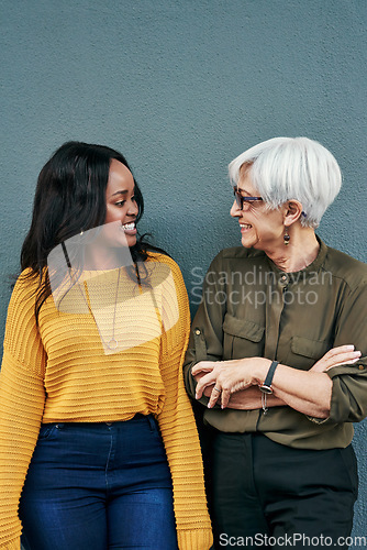 Image of Black woman, senior businesswoman and talking on break or conversation with employee, friend or mentor. Women, mature colleague or happy together and discussion outside work on blue background