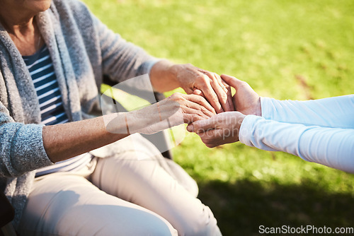 Image of Senior woman, caregiver and holding hands in care, support or love for healthcare or life insurance. Hand of nurse helping mature patient in wheelchair or person with a disability at nursing home