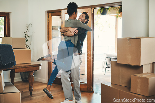 Image of Happy couple, hug and real estate moving in new home for relocation, renovation or investment together. Interracial man hugging woman and homeowners with boxes in house for move, mortgage or property