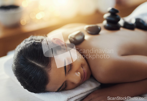 Image of Happy woman, relax and sleeping in rock massage at spa for skincare, beauty or body treatment. Calm female asleep in relaxation with hot rocks or pile on back in therapy, zen or wellness at salon