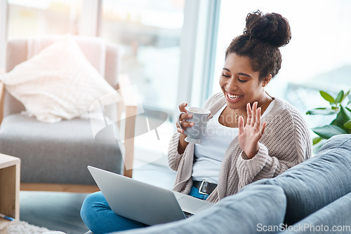 Image of Happy woman, laptop and video call on home sofa with a smile and hand to wave hello. Real female person relax on a couch with coffee, internet connection and tech to talk online for communication