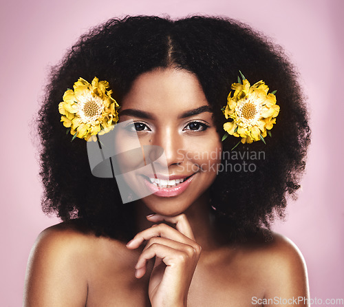 Image of Portrait, happy woman and hair care with yellow flowers in studio, pink background or natural beauty. Face of african model, skincare and daisy plants in afro for sustainable cosmetics, smile or glow