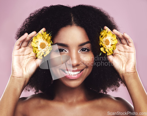 Image of Happy woman, hair and daisy flowers in studio, pink background and floral aesthetic of natural beauty. Portrait, face and african model with yellow plants, afro and smile for vegan cosmetic skincare