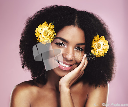 Image of Portrait, face and happy woman with flowers in afro, studio and pink background for beauty, floral aesthetic and shine. African model, natural skincare and daisy plants in hair for organic cosmetics