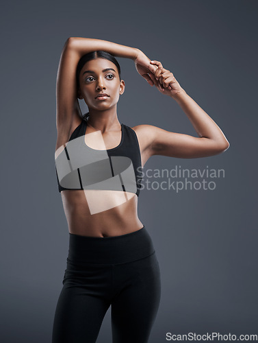 Image of Idea, mockup and stretching with an athlete woman in studio on a gray background for fitness or health. Exercise, thinking and warm up with an attractive young female model training her body