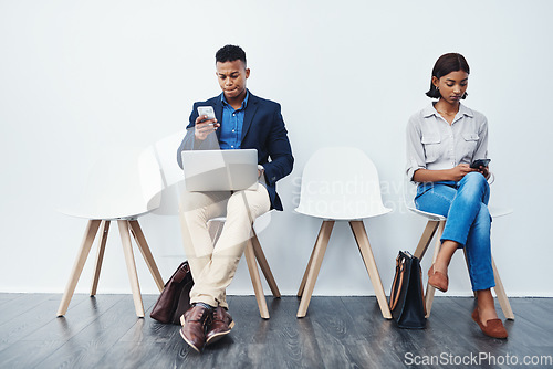 Image of Phone, laptop and people in interview waiting room and search the internet, web or website sitting on chairs. Internship, work and young employees texting or typing online ready for a new job