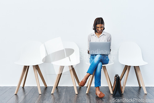 Image of Laptop, internet and woman in interview waiting room and she search a website, connection or web sitting on chairs. Internship, work and young female person email online ready for a new job