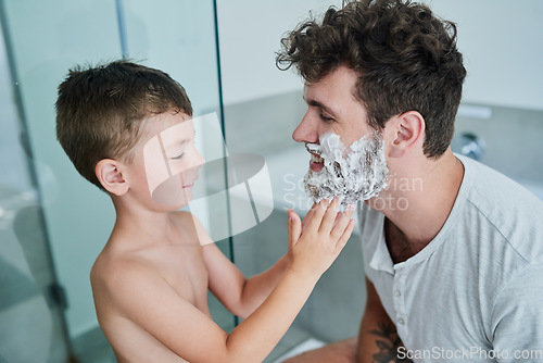 Image of Father, kid and learning how to shave in bathroom, having fun or bonding together. Smile, child and dad teaching with shaving cream on face, playing and cleaning, hygiene and enjoying quality time.