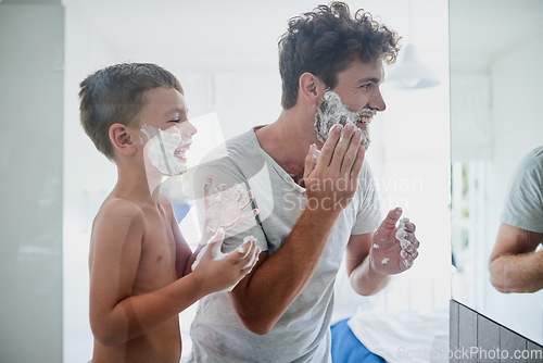 Image of Kid, father and learning to shave, laughing and bonding together in bathroom. Funny, dad and teaching child with shaving cream on face beard, playing or cleaning, hygiene or enjoying hair removal.