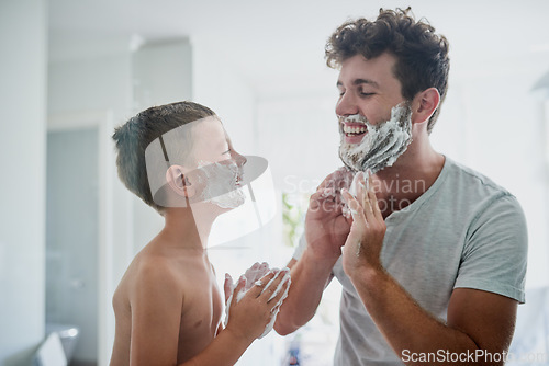 Image of Kid, father and learning to shave, funny or bonding together in home bathroom. Laughing, dad and teaching child with shaving cream on face beard, playing or cleaning, hygiene or enjoying hair removal