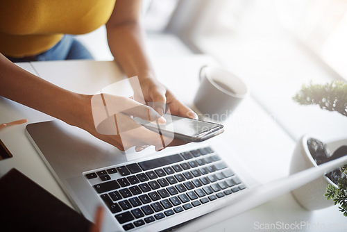 Image of Woman, hands and phone online at a laptop for work networking and employee typing. Female worker, table and social network app with mobile communication and text for professional and web connection