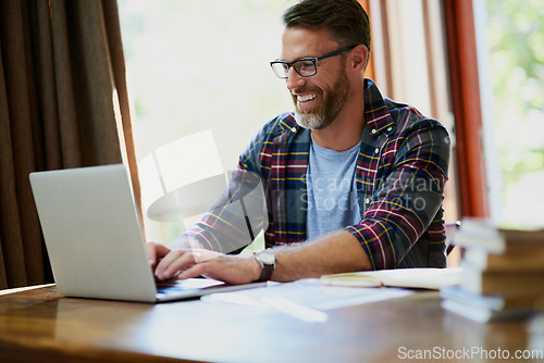 Image of Man, laptop and working from home while typing for search, email or streaming online for research. Freelancer and entrepreneur with internet connection and books for remote work, planning or learning