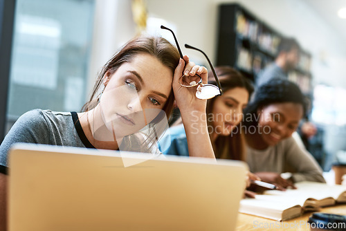 Image of Woman, stress and laptop for studying at library, college or campus with tired face, anxiety or burnout. University student, girl and computer for education, study and fatigue at school with reading