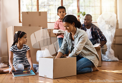 Image of Family, moving and packing boxes into home living room together with children, mom and dad. Property, real estate investment and house move with couple, kids helping box and cardboard unpacking