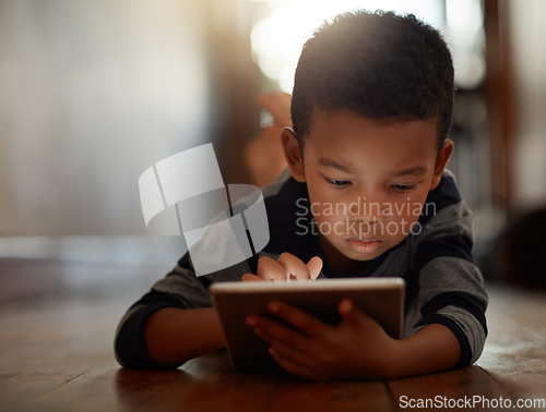 Image of Learning, little boy and on digital tablet or playing games or streaming video on the internet and lying on the floor at home on bokeh. Technology, device and male child downloading app or reading