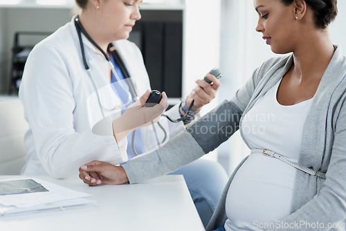 Image of Blood pressure, gynecology and doctor with a pregnant woman for a consultation of health. Hospital, wellness check and a medical worker with a patient consulting about hypertension during pregnancy