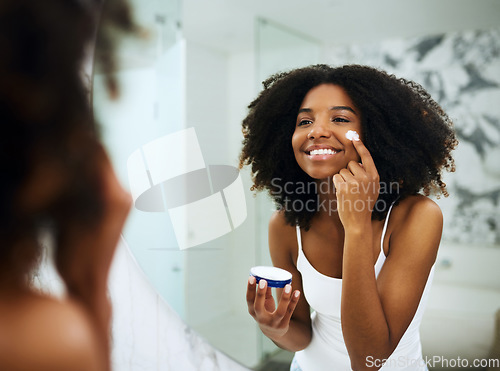 Image of Skincare, bathroom mirror and black woman with cream, smile and morning dermatology routine. Health, wellness and luxury skin care at home, girl in reflection with lotion on face for facial treatment