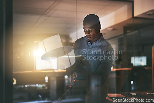 Image of Black business man, night and tablet with reading, planning or focus for deadline, research or project. African businessman, digital touchscreen and web design with ux, website or typing in workplace