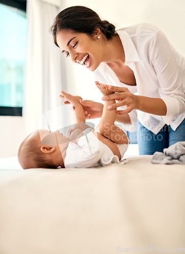 Image of Happy, love and a mother with her baby on the bed in their home together for playful bonding. Family, children and a young mama spending time with her newborn infant in the bedroom for fun or joy