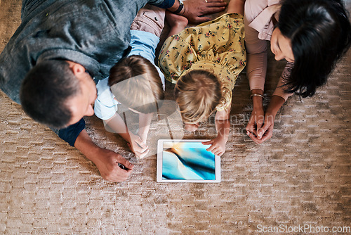 Image of Tablet, screen and family streaming online content or social media on the internet and bonding in a home floor. Relax, mother and top view of father with children or kids in the living room using app