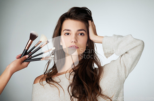 Image of Makeup brush, face and beauty of a woman in studio with a natural glow. Portrait of a female model person on a grey background and hands for cosmetology transformation, powder cosmetics and skin care