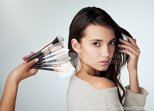 Image of Beauty, makeup brush and face of a woman in studio with a natural glow. Portrait of a female person on a grey background with a hand for cosmetology tools, powder cosmetics and facial skin care