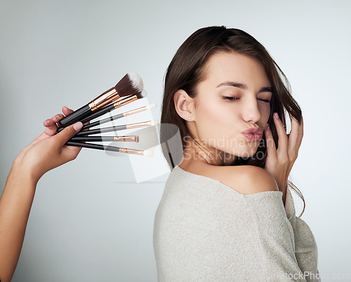 Image of Face, makeup brush and beauty of a woman in studio with a natural glow and shine. Headshot of a female person on a grey background with a hand and lips for cosmetology, facial cosmetics and skin care