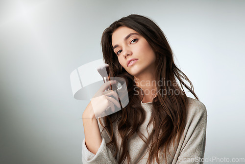 Image of Face, makeup brush and beauty of a woman in studio with a natural glow. Portrait of a female model person on a grey background with mockup for cosmetology, powder cosmetics and facial skin care