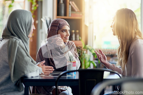 Image of Friends, smile and Muslim women in cafe, bonding and talking together. Coffee shop, happy and Islamic girls, group or people in conversation, chat and discussion for social gathering in restaurant.