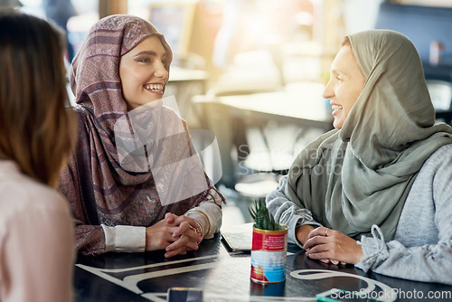 Image of Friends, funny and Muslim women in cafe, bonding and talking together. Coffee shop, happy and Islamic girls, group or people laughing, conversation and discussion for social gathering in restaurant.