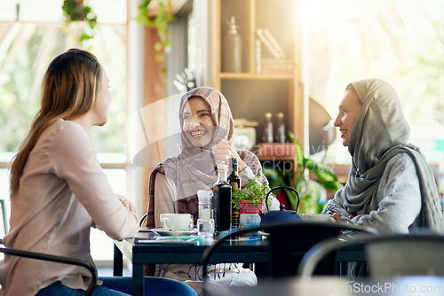 Image of Friends, funny and Muslim women in cafe, bonding and talking together. Coffee shop, happy and Islamic girls, group or people laughing, conversation and discussion for social gathering in restaurant.