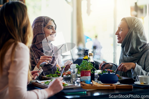 Image of Muslim women, friends and lunch in restaurant, together and talking with food, smile and happiness. Islamic woman, group and eating brunch with conversation, happy face and listen with food in cafe