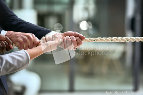 Image of Hands, teamwork and rope with business people pulling during a game of tug of war in the office. Collaboration, help and strength with a team of employees or colleagues holding onto an opportunity