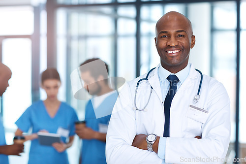 Image of Leader, man and portrait of doctor in hospital, healthcare or clinic with medical expert nurses to trust in quality care. Black man, medicine and happy neurosurgeon with arms crossed in confidence