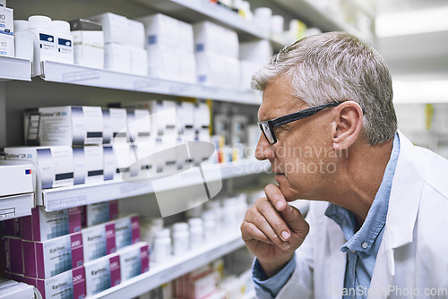 Image of Pharmacy, medicine and thinking with man at shelf in drug store for search, inspection and inventory. Medical, healthcare and pills with senior male pharmacist for expert, wellness and product