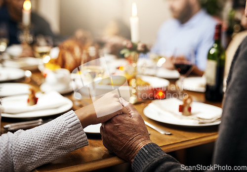 Image of Closeup, thanksgiving and hand holding with family at table in dining room for holiday, food or worship. Celebration, support and gratitude with people praying at home for kindness, dinner and love