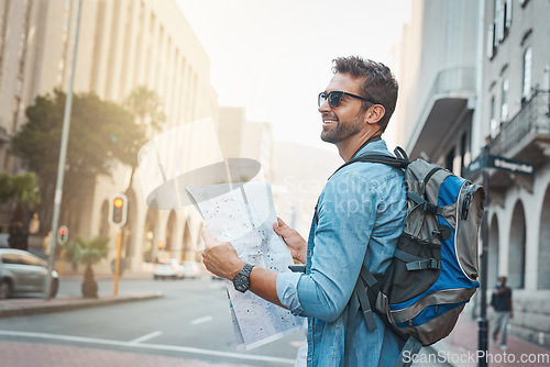 Image of Man, tourist and a map in a city for travel on a street with a backpack for location or direction. Male person with paper for navigation outdoor on urban road for adventure, journey or vacation