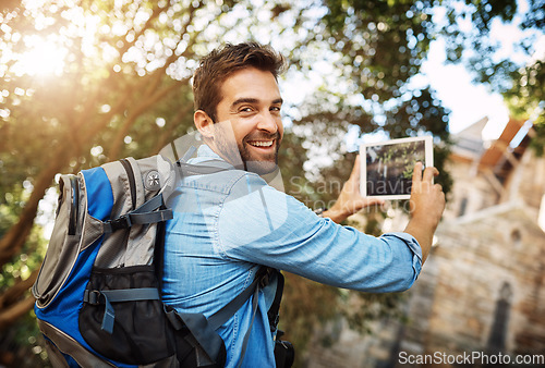Image of Man, tourist and tablet for travel photo outdoor in nature with a backpack and smile. Portrait of male person with tech for hiking adventure, journey or vacation photography and freedom or happiness