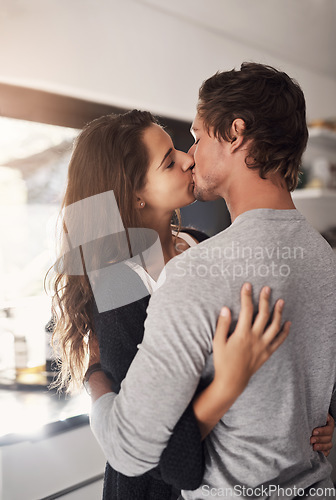 Image of Young, couple and kissing in home for love, romantic bond and intimacy of special moment together. Man, woman and romance of partners with kiss for happy relationship, passionate affection and care