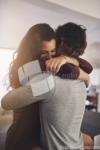 Image of Woman, man and hug in home for love, care and quality time together with commitment to relationship. Happy young couple, hugging and romance of lovers, smile and relax with trust of partner in house