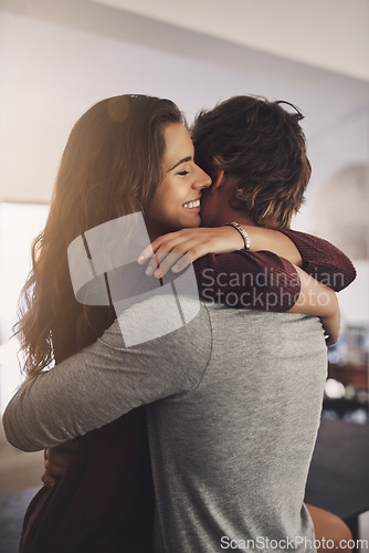 Image of Happy woman, man and hug in home for love, care and quality time together with commitment to relationship. Young couple, hugging and anniversary of lovers, smile and happiness of loyalty to partner