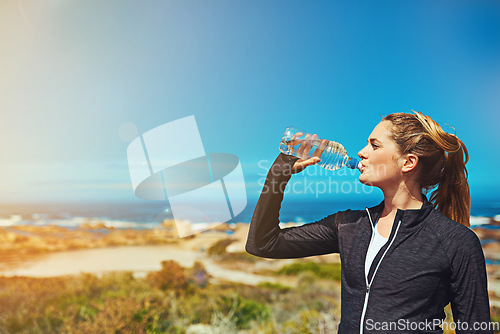 Image of Woman drink water, beach and fitness with blue sky, athlete outdoor with hydration and mockup space. Exercise by the sea, female person drinking h2o from bottle with workout and break from training