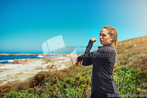 Image of Woman at beach, stretching arms with fitness and health, young athlete workout outdoor with focus and blue sky. Active female person in nature, warm up by ocean and exercise with mockup space