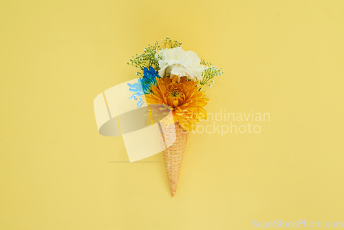 Image of Floral ice cream in a cone in a studio for art, creativity or decoration with fresh and colorful bouquet. Creative, still life and blossom flowers or plants in a dessert isolated by yellow background