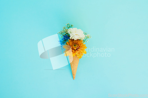 Image of Floral, ice cream and cone in studio for creativity, art or decoration with fresh and colorful bouquet. Creative, still life and flower plants in dessert isolated by blue background with mockup space