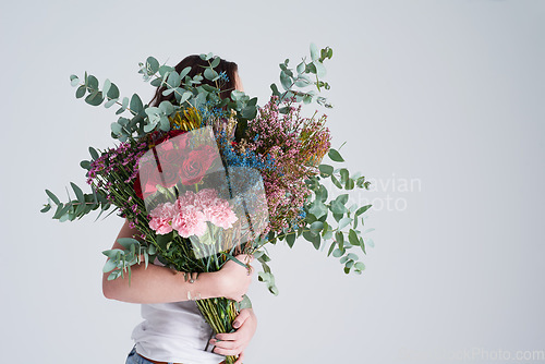 Image of Natural, gift and woman with flowers, spring and eco friendly against grey background. Female person, model and girl with a floral present, bouquet or hide face with sustainability, nature and plants