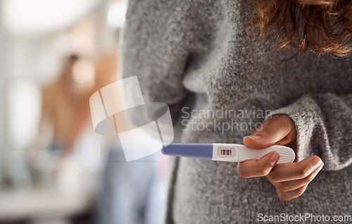 Image of Closeup, surprise and hands of a woman with a pregnancy test for husband at home. Showing, back and a person holding and hiding a tool with pregnant results during announcement to a man in a house