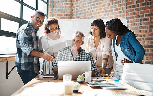 Image of Teamwork, group and colleagues using a laptop together or collaboration on a new project and in a modern office. Diversity, idea and businesspeople in a meeting or having a conversation and work