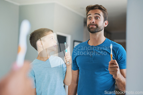 Image of Funny face, brushing teeth and father with son in bathroom mirror for morning routine, comic and dental. Oral hygiene, cleaning and smile with man and child in family home for self care and wellness