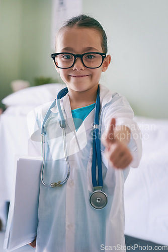 Image of Girl child, playing and doctor thumbs up in portrait with smile, glasses and stethoscope in hospital. Female kid, play medic and happy with excited face, learning and hand sign for yes emoji in house